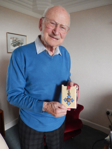 John holding his CBE